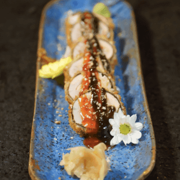 Eskulacho Roll — Mix de peixes do dia, envolto na alga marinha empanado no Panko condimentado com geleia de pimenta e geleia de alho negro, cebolinha verde e gergelim.